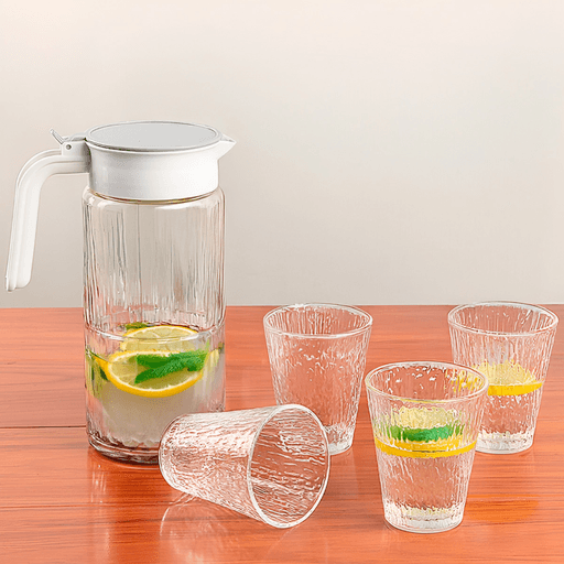 Este set de jarra con cuatro vasos combina funcionalidad y estilo para acompañarte en cada momento. Fabricado en vidrio resistente, es ideal para servir bebidas frías de forma práctica y segura gracias a su tapa con vertido controlado. Su diseño moderno y minimalista lo hace perfecto tanto para el uso diario como para ocasiones especiales.

