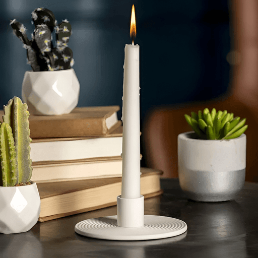 Agregá un toque de elegancia y calidez a tu hogar con este portavelas circular de resina símil cerámica acanalado. Su acabado en blanco combina con cualquier estilo decorativo, realzando la belleza de tu sala de estar, comedor o dormitorio. Diseñado para sostener velas cónicas de tamaño estándar, este portavelas es ideal como centro de mesa o decoración de estantes. Su fabricación en resina símil cerámica resistente garantiza durabilidad y sofisticación. Perfecto para regalar en cualquier ocasión.